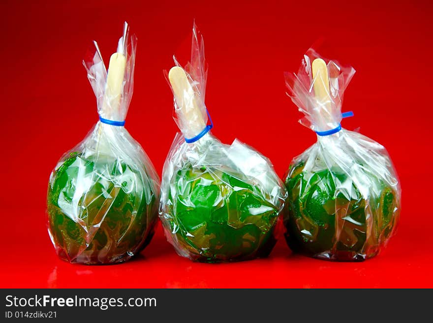 Toffee apples isolated against a green background