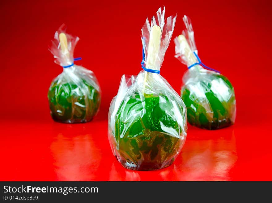 Toffee apples isolated against a green background