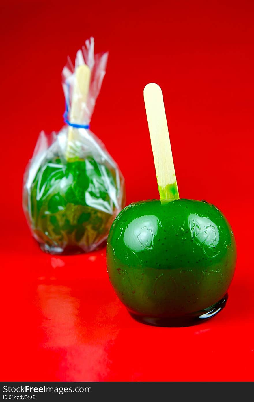 Toffee apples isolated against a green background