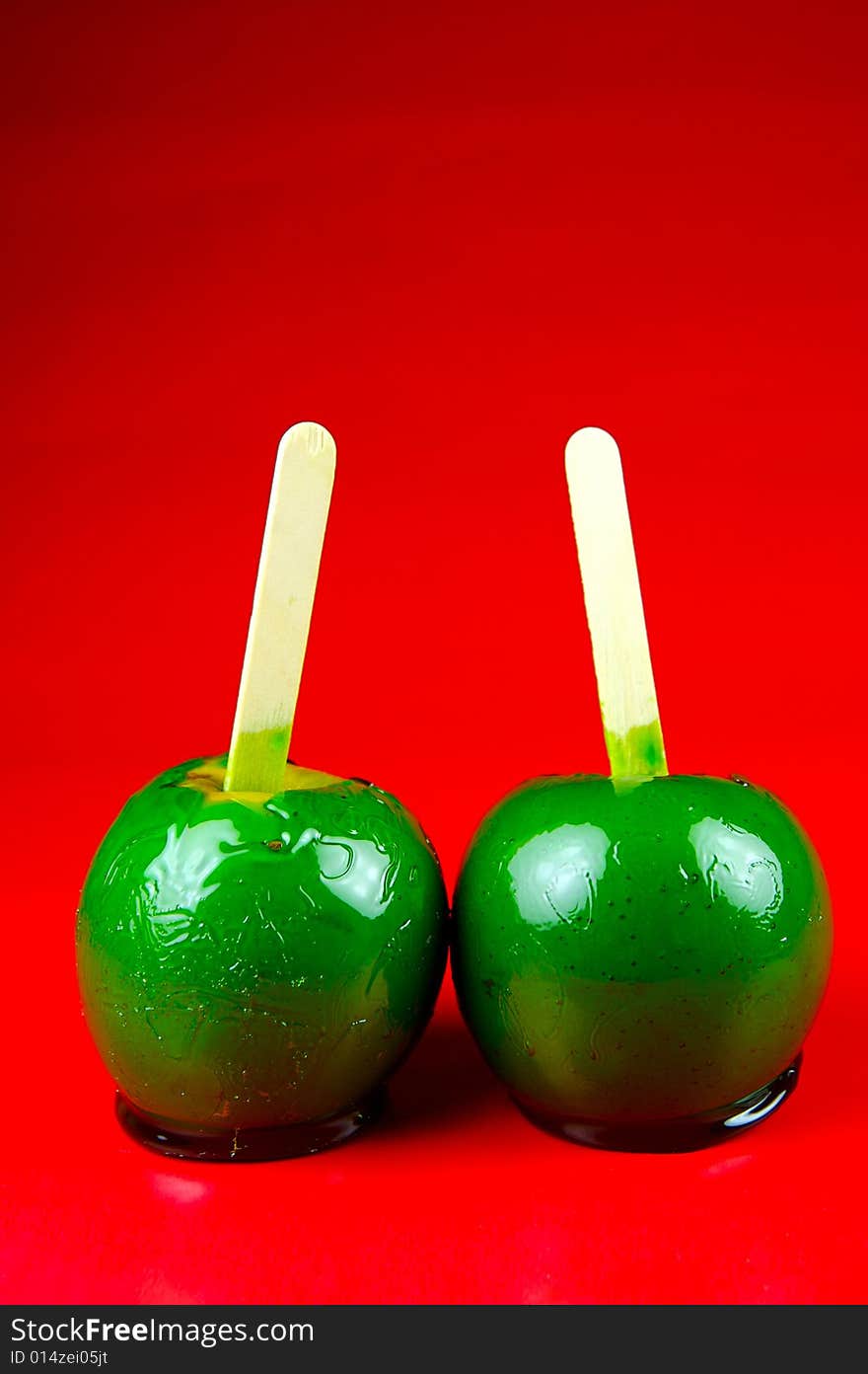 Toffee apples isolated against a green background