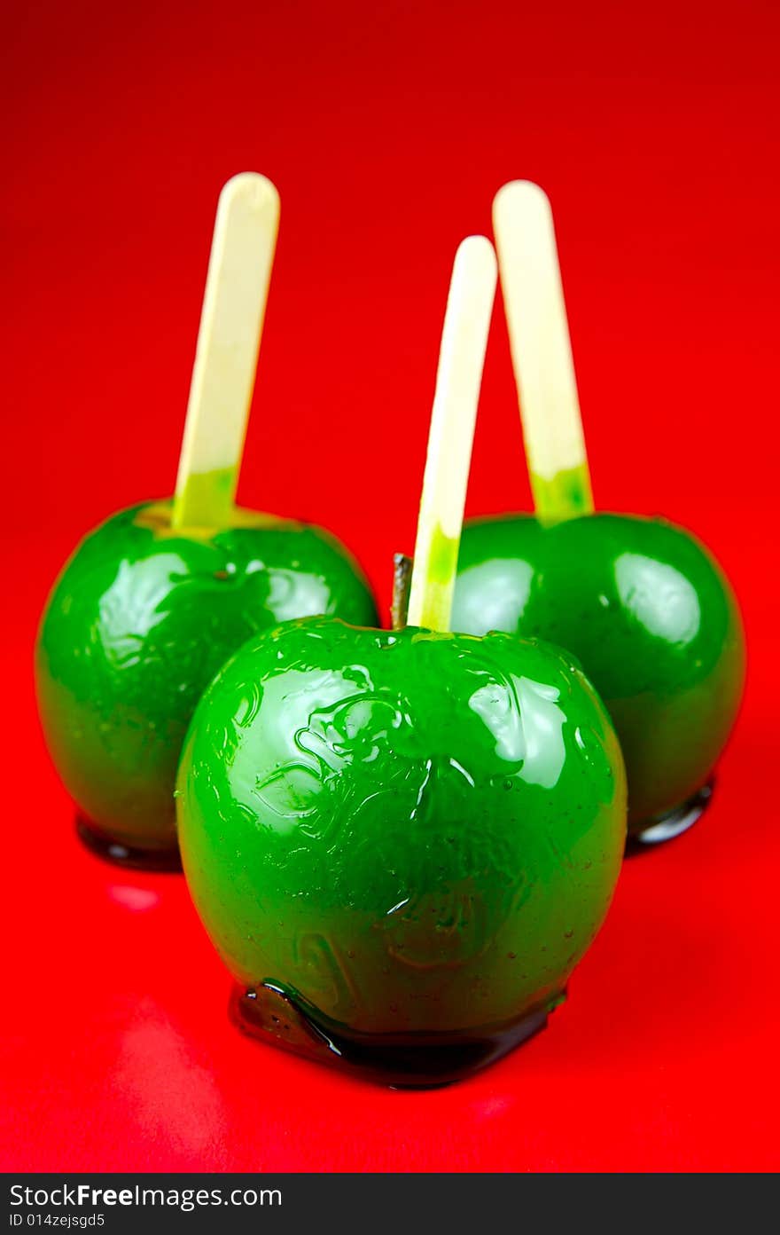 Toffee apples isolated against a green background