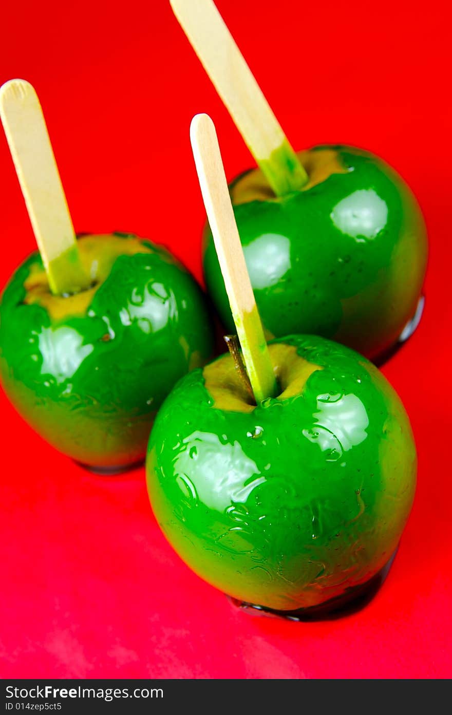 Toffee apples isolated against a green background