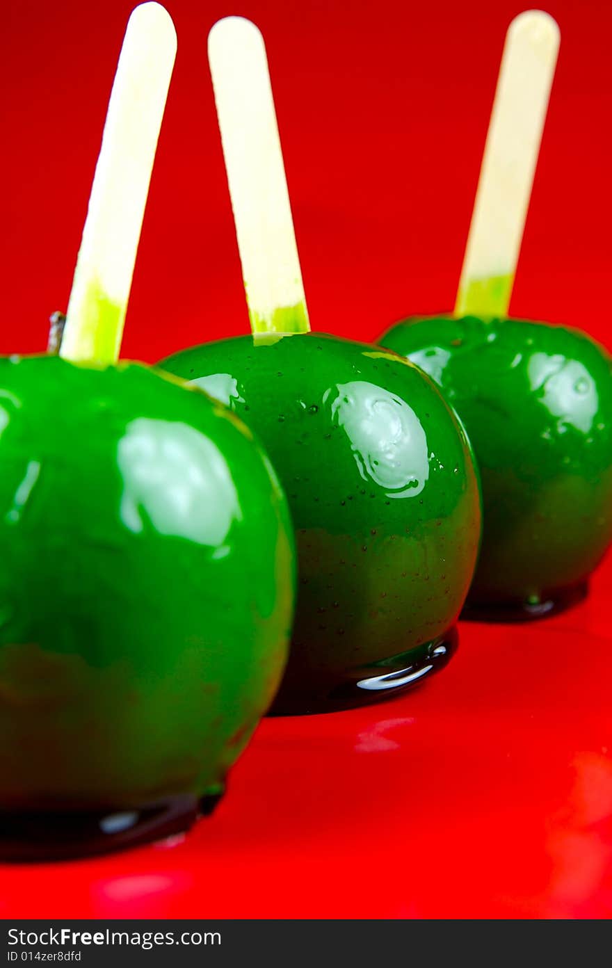 Toffee apples isolated against a green background