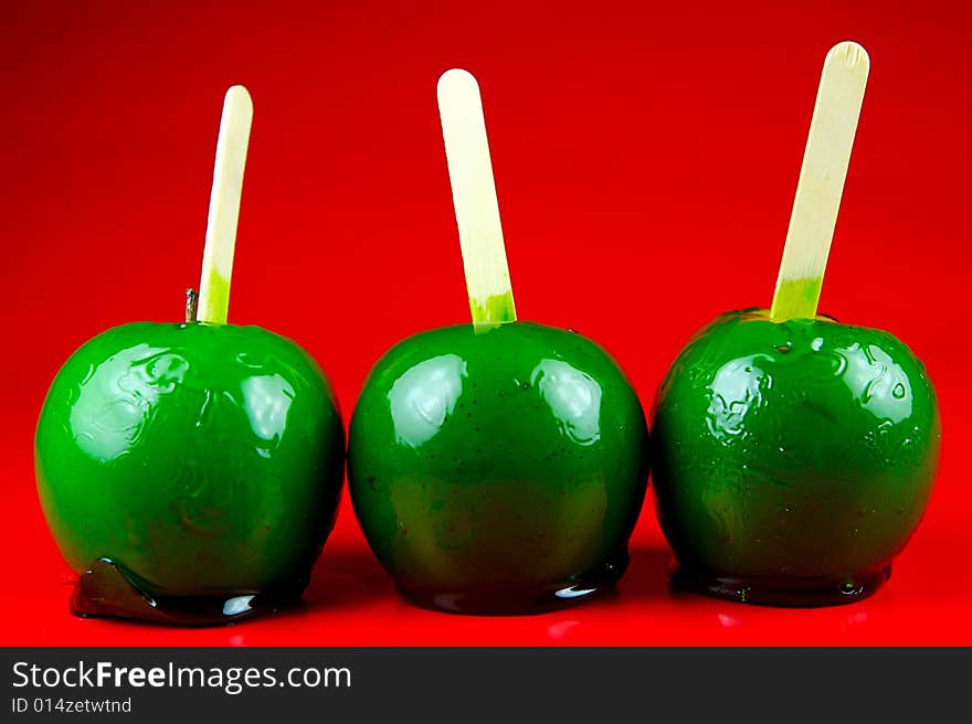 Toffee apples isolated against a green background