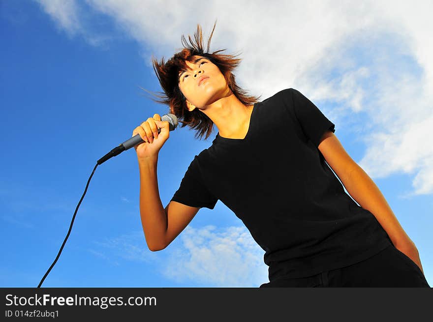 Picture of a young generation rock star with a microphone. Suitable for musical related contexts. Picture of a young generation rock star with a microphone. Suitable for musical related contexts.