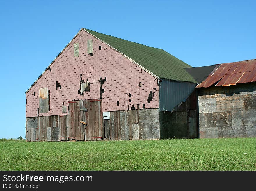 Old barn with grass and blue sky