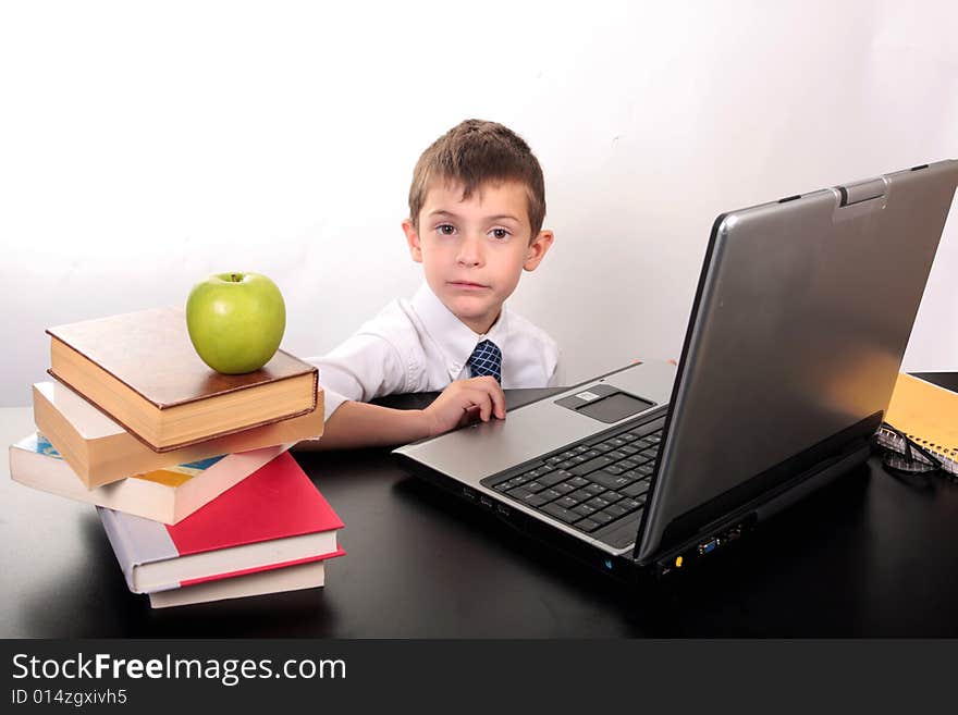 Little boy sitting at his desk in front of a laptop computer. Little boy sitting at his desk in front of a laptop computer