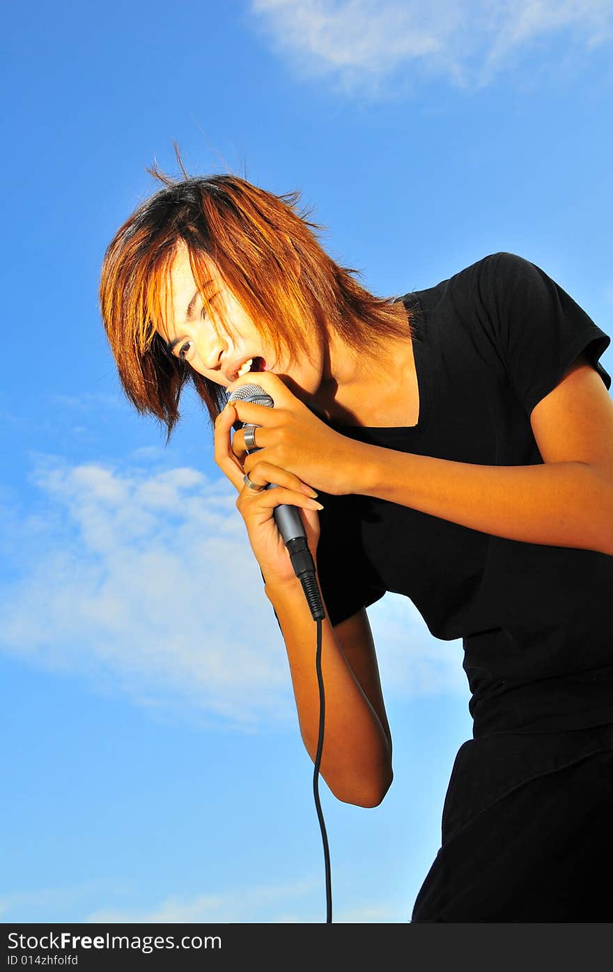 Picture of a young generation rock star with a microphone. Suitable for musical related contexts. Picture of a young generation rock star with a microphone. Suitable for musical related contexts.