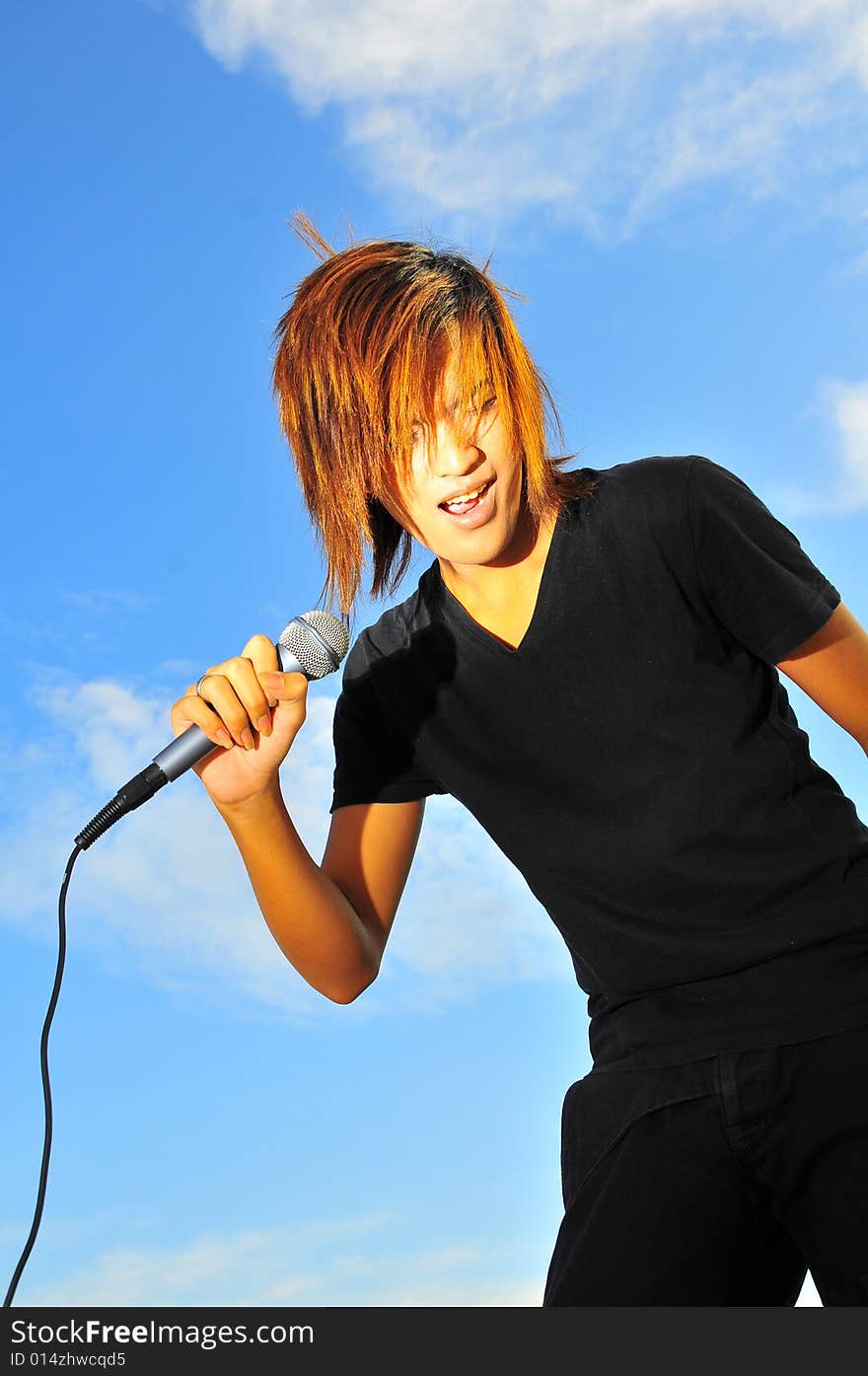 Picture of a young generation rock star with a microphone. Suitable for musical related contexts. Picture of a young generation rock star with a microphone. Suitable for musical related contexts.