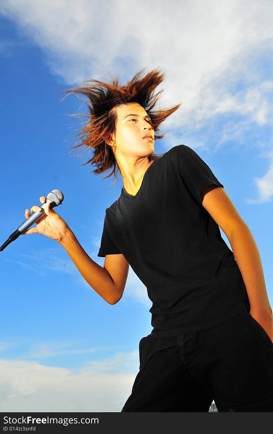 Picture of a young generation rock star with a microphone. Suitable for musical related contexts. Picture of a young generation rock star with a microphone. Suitable for musical related contexts.