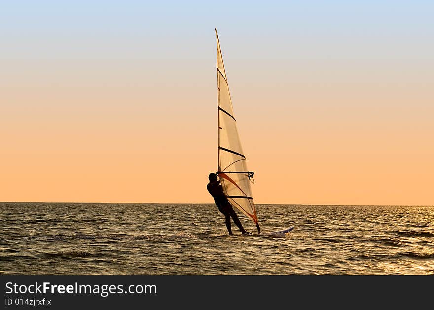 Silhouette of a windsurfer on waves