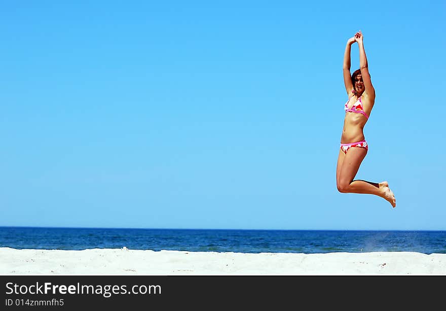 Young attractive woman jump on the beach. Young attractive woman jump on the beach