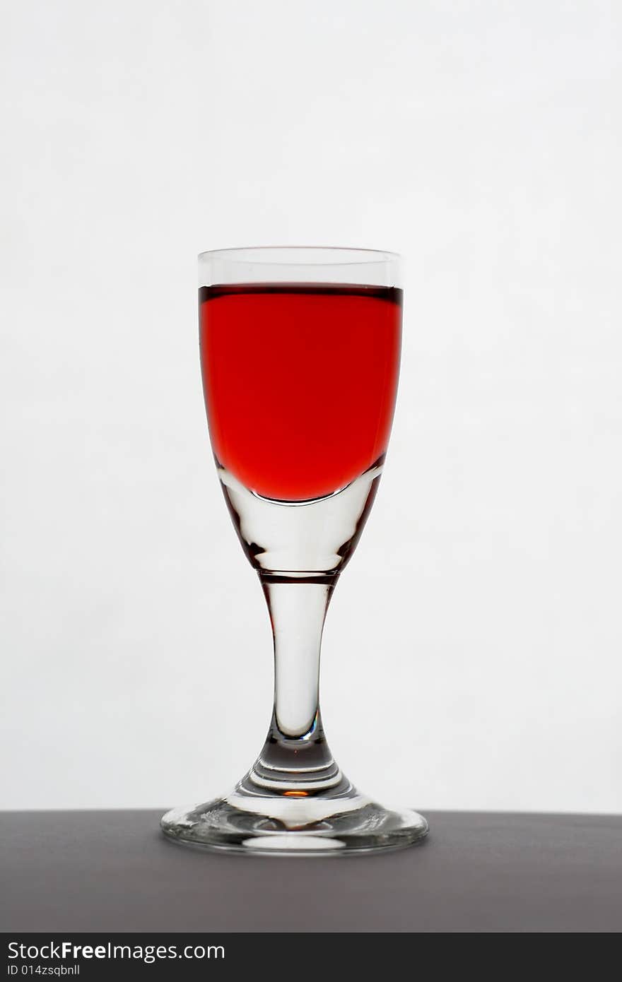 A glass of wine on the table, over white background