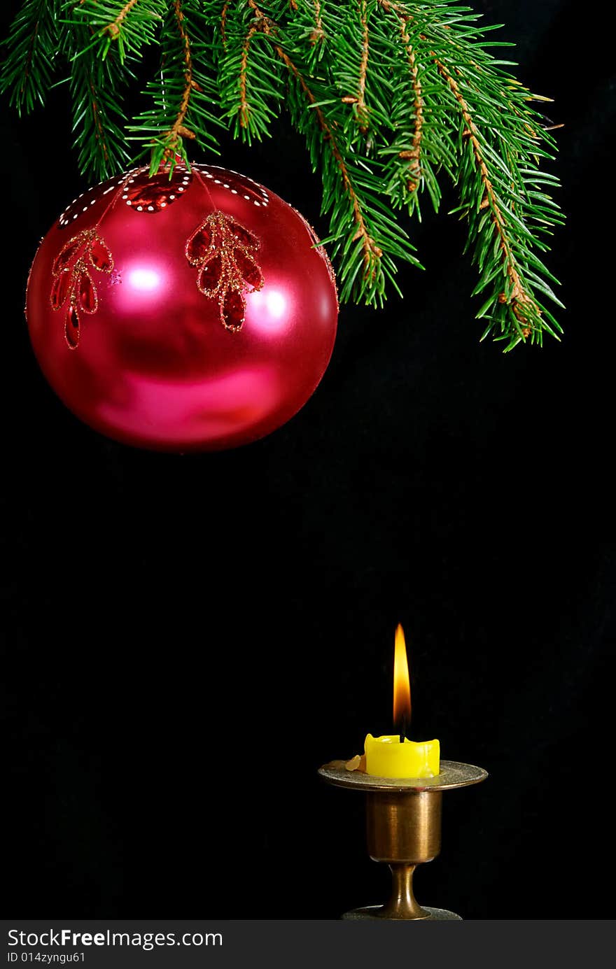 Green  fir tree  twig and red ball and candle. Green  fir tree  twig and red ball and candle