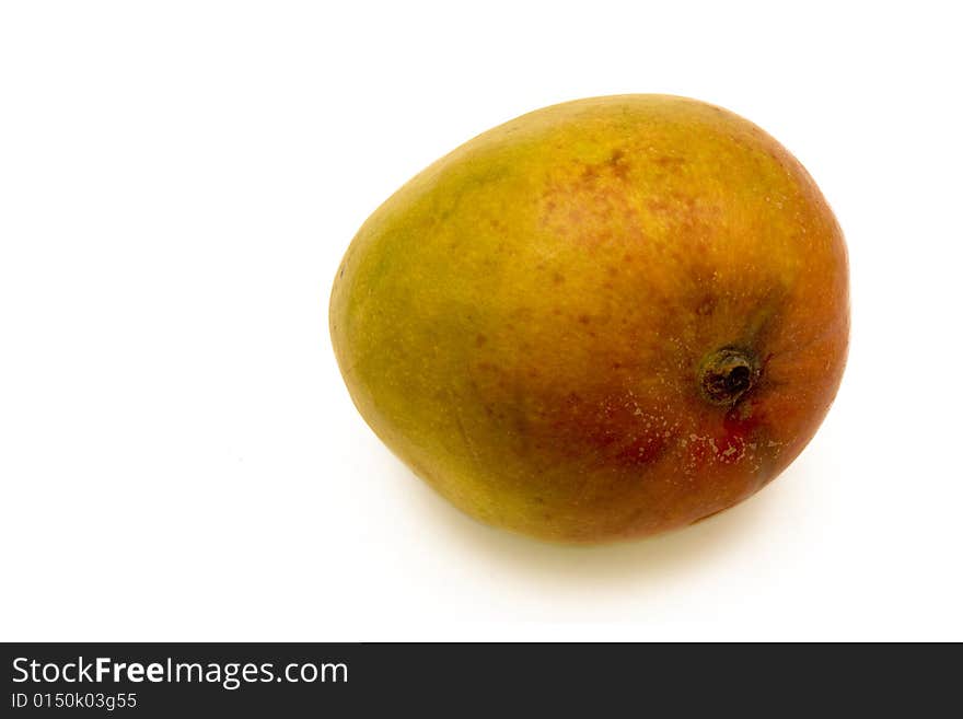 A ripe mango fruit isolated on white with a soft shadow. A ripe mango fruit isolated on white with a soft shadow