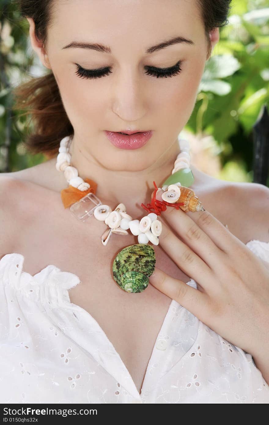 A beautiful young brunette woman wearing a necklace. A beautiful young brunette woman wearing a necklace