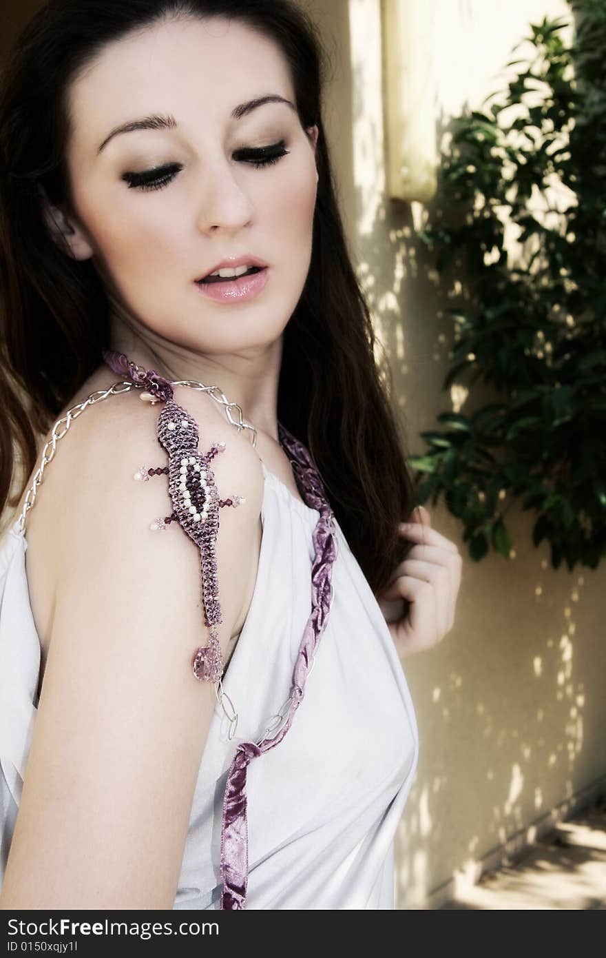 A beautiful young brunette woman wearing a necklace. A beautiful young brunette woman wearing a necklace