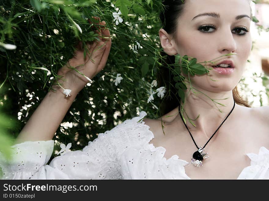 A beautiful young brunette woman wearing a necklace. A beautiful young brunette woman wearing a necklace