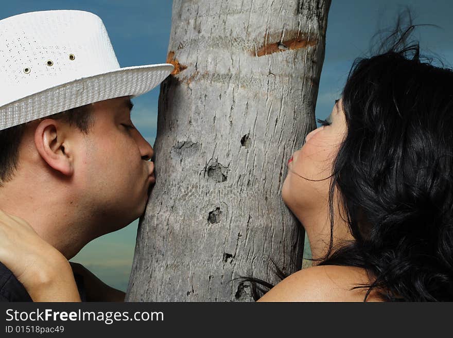 Young couple kissing a tree