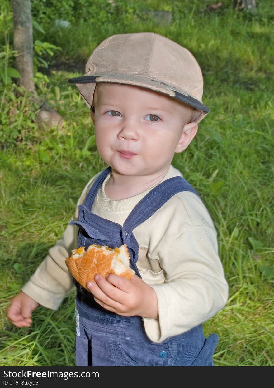 Kid eating the helthy food roll in the park outdoor. Kid eating the helthy food roll in the park outdoor