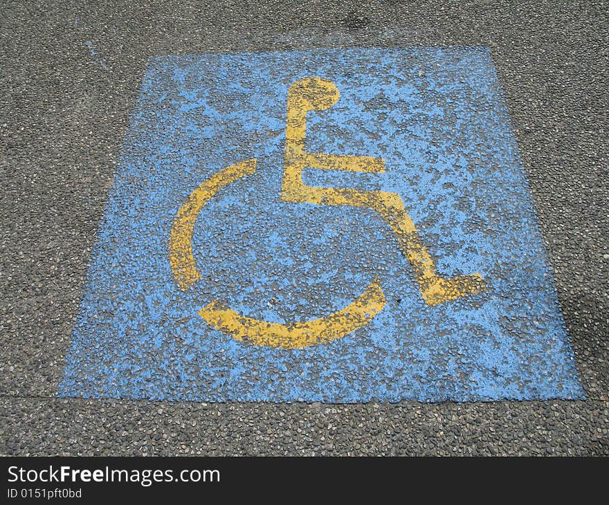 Blue and yellow painted wheelchair parking sign