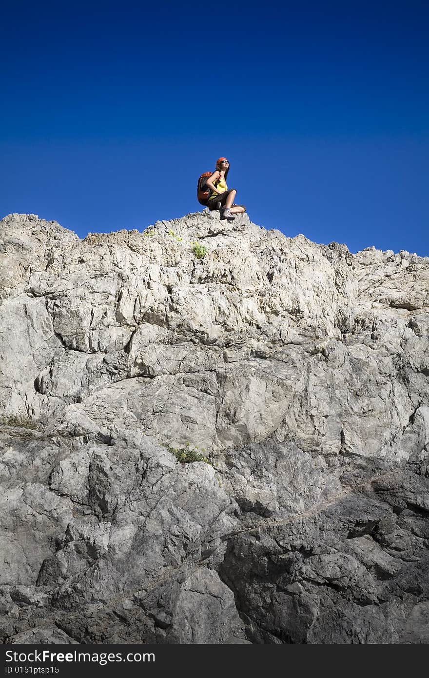 Young woman resting on top of the mountain after hiking