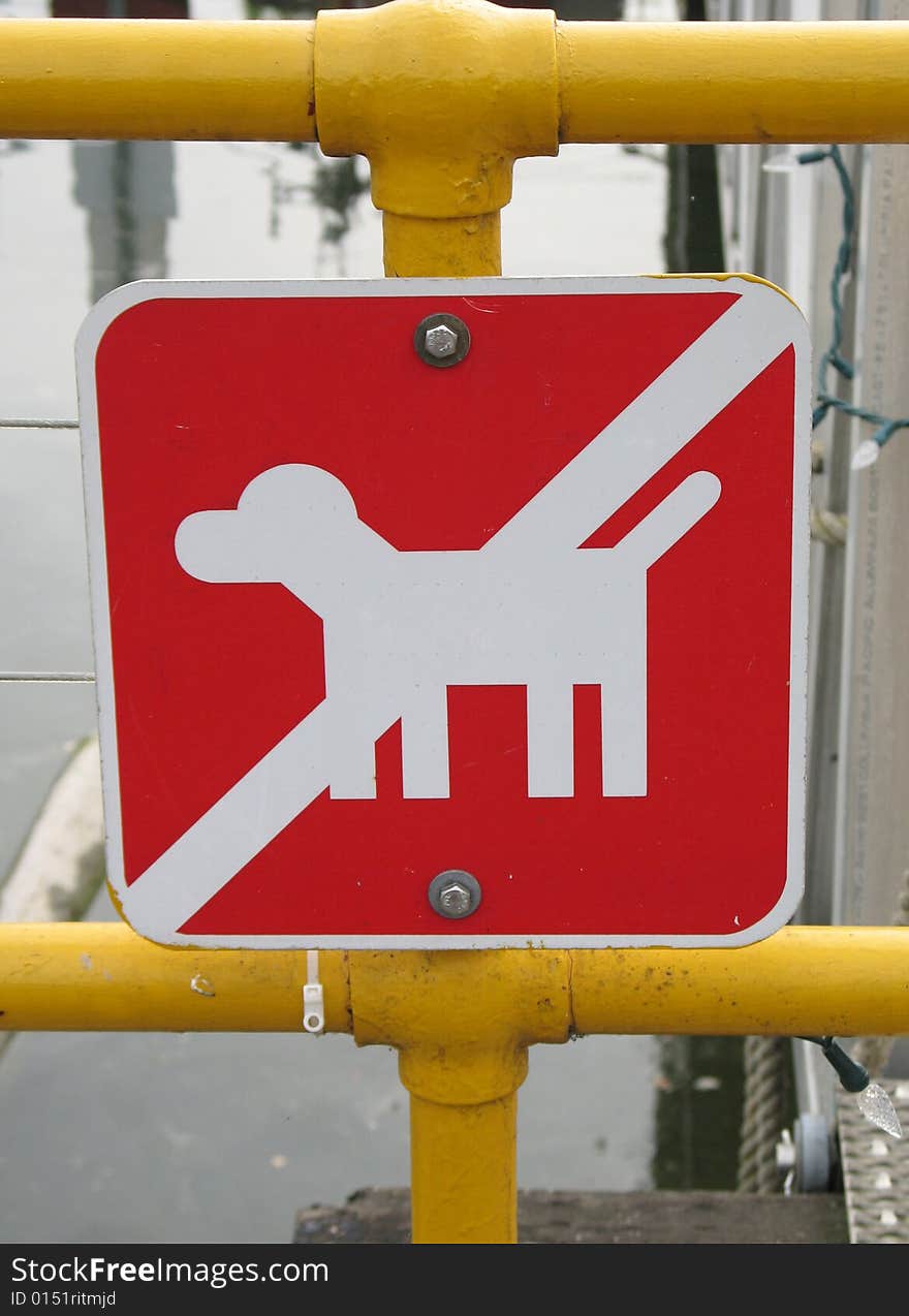 Red no dog sign on a yellow fence