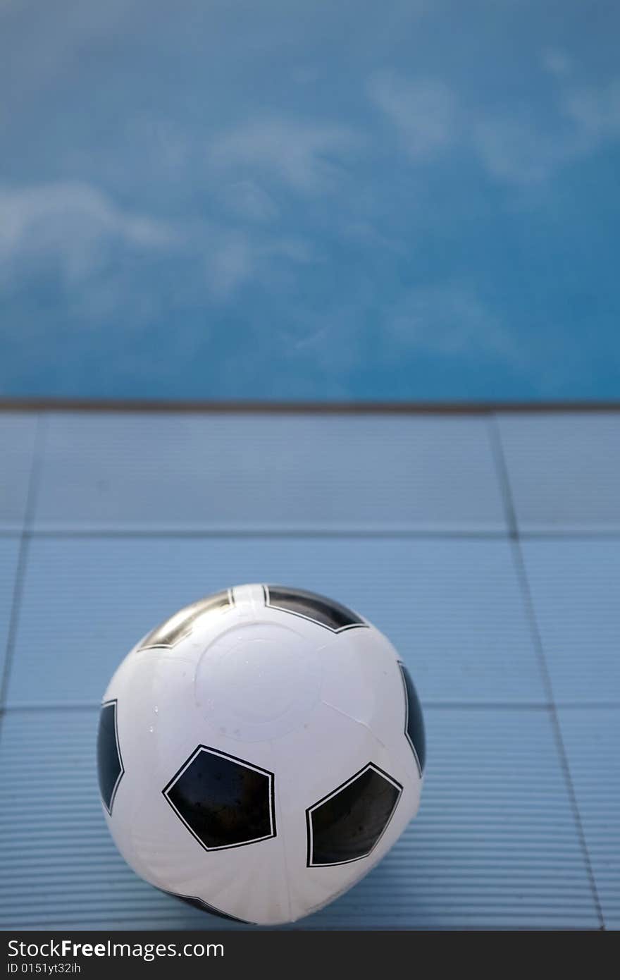 Inflatable plastic ball floating on a calm swimming pool