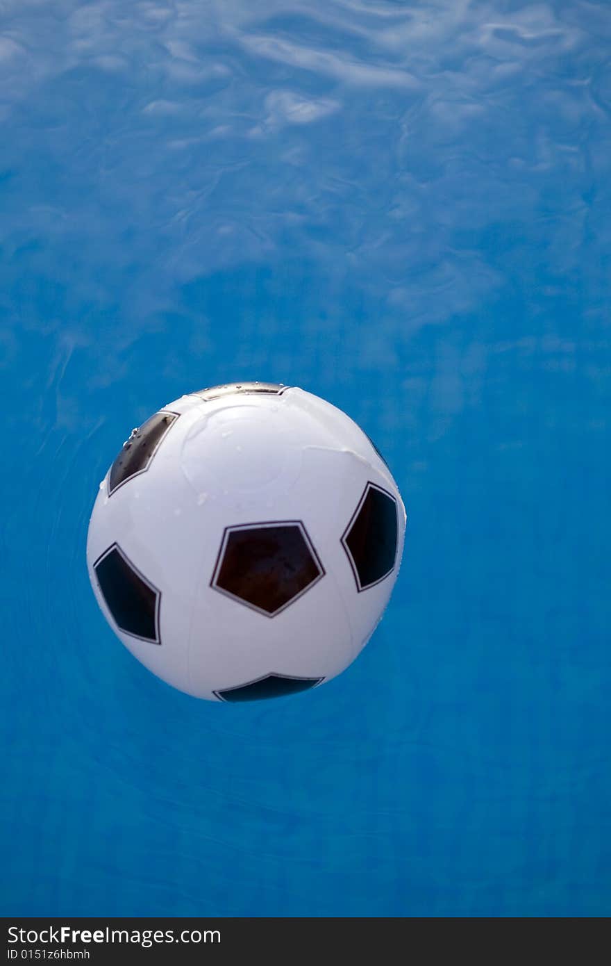 Inflatable plastic ball floating on a calm swimming pool