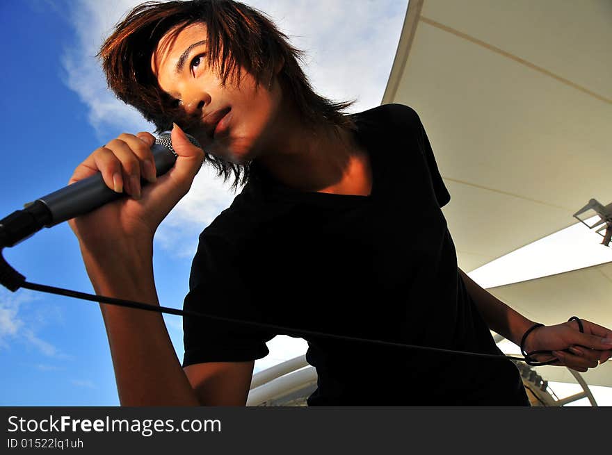 Picture of a young generation rock star with a microphone. Suitable for musical related contexts. Picture of a young generation rock star with a microphone. Suitable for musical related contexts.