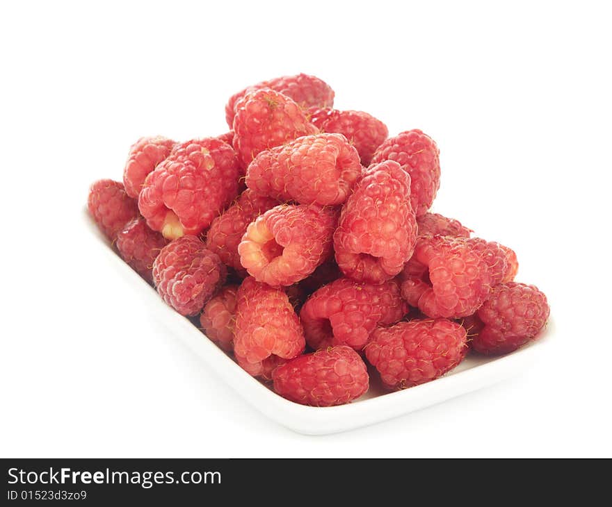 Several ripe raspberries in small plate isolated on white