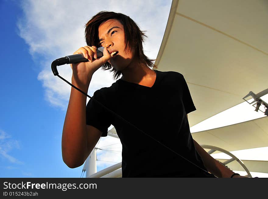 Picture of a young generation rock star with a microphone. Suitable for musical related contexts. Picture of a young generation rock star with a microphone. Suitable for musical related contexts.