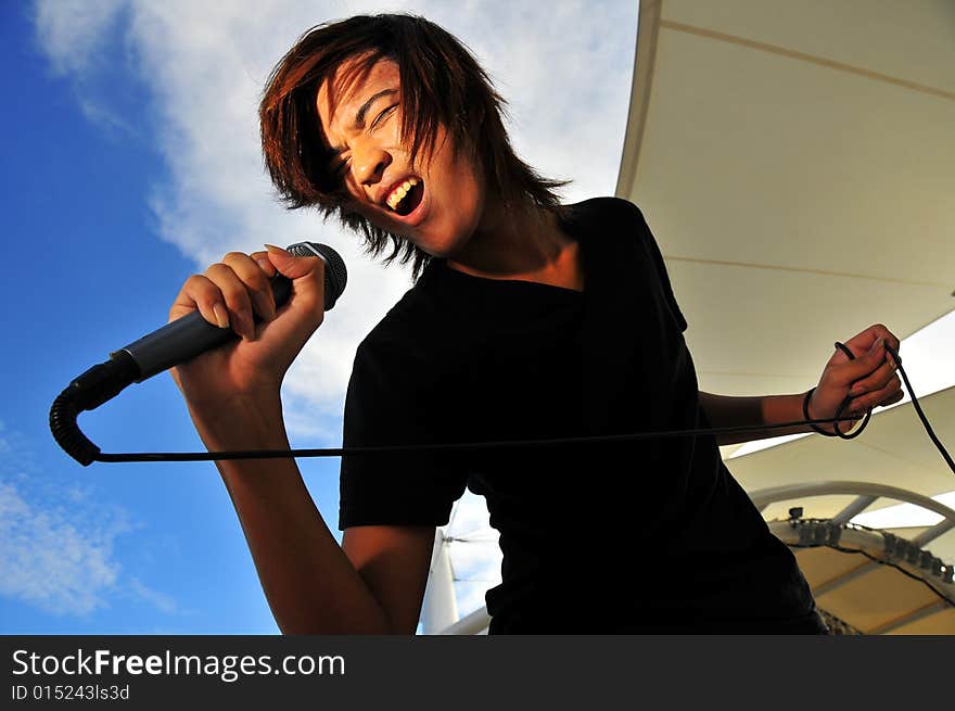 Picture of a young generation rock star with a microphone. Suitable for musical related contexts. Picture of a young generation rock star with a microphone. Suitable for musical related contexts.