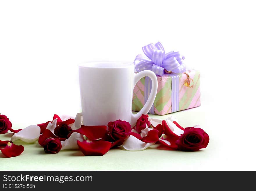 White cup and rose petals and heads with present isolated on white background