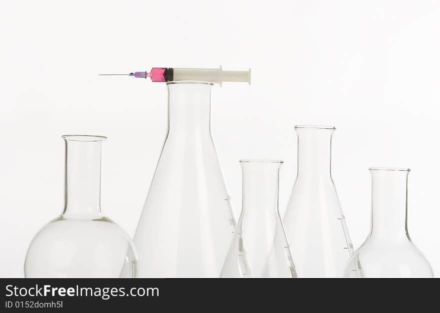 Assorted glassware and syringe in research laboratory. Assorted glassware and syringe in research laboratory