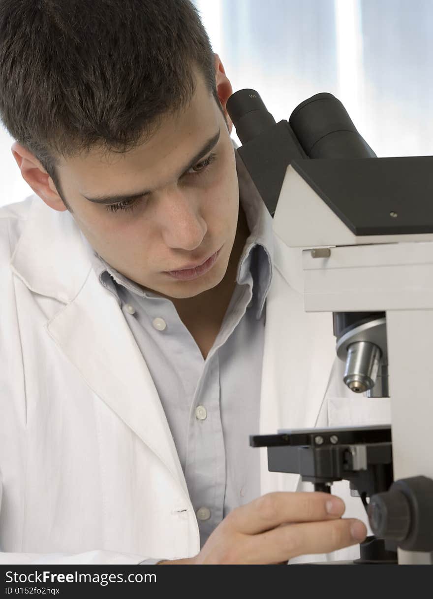 Young scientist watching inside a microscope