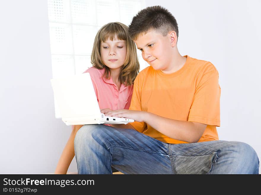 Young boy showing to girl something in laptop. Young boy showing to girl something in laptop.