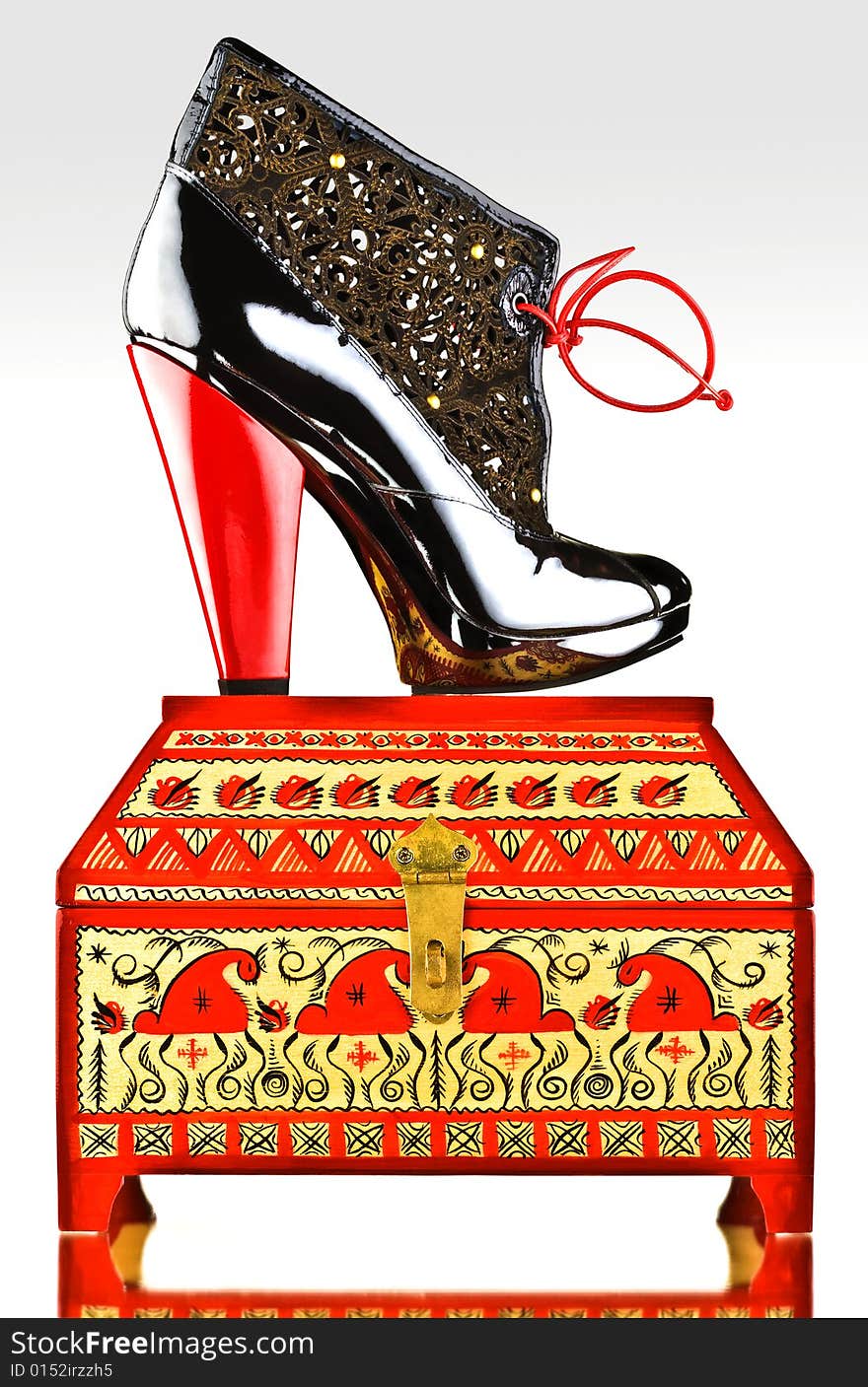 Fancy boot with red heel and laces on decorated jewelery box. Fancy boot with red heel and laces on decorated jewelery box.