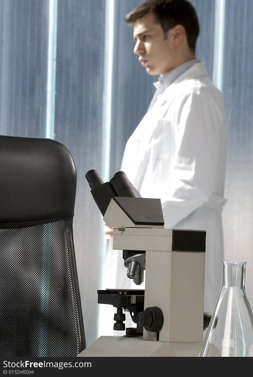 Scientist thinking in his lab near the microscope. Scientist thinking in his lab near the microscope