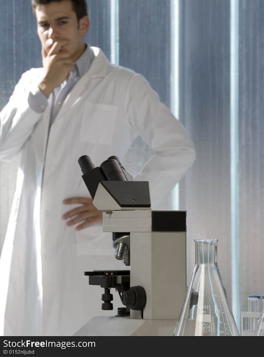 Scientist thinking in his lab near the microscope. Scientist thinking in his lab near the microscope