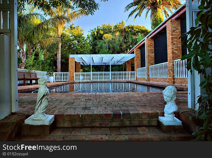 Entrance into outdoor swimming pool with sculptures. Shot in farm near Stellenbosch, Western Cape, South Africa.