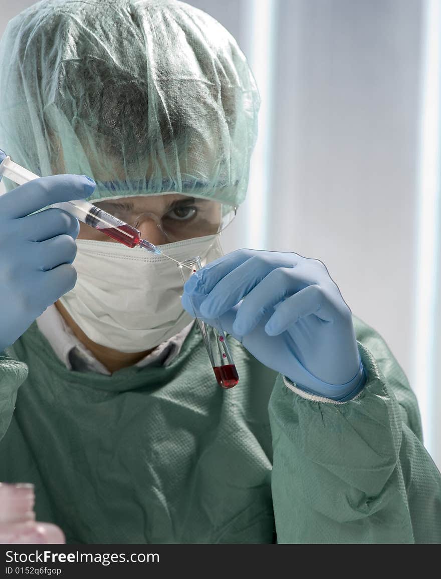 Scientist working in his laboratory with flask and syringe. Scientist working in his laboratory with flask and syringe