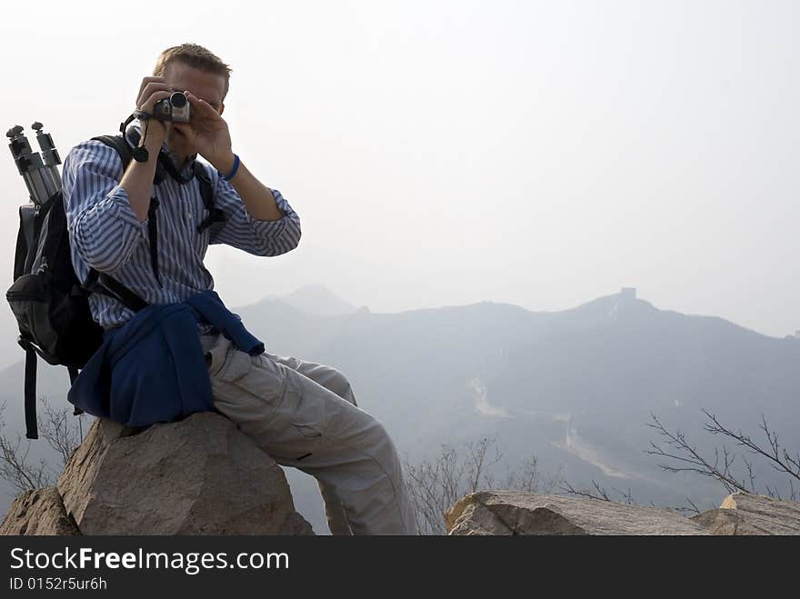 Man taking pictures or video atop the Great Wall of China