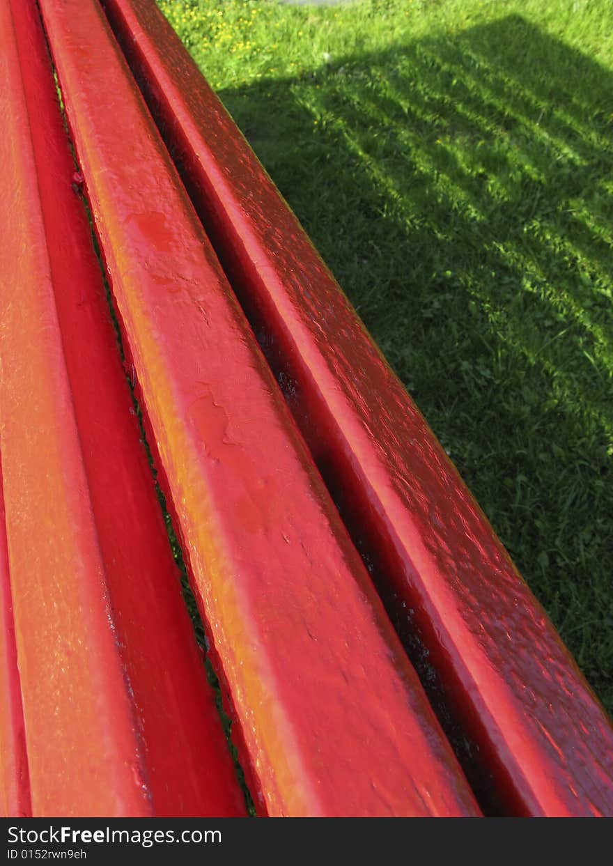 Painted wooden boards and shadow on  green herb in park. Painted wooden boards and shadow on  green herb in park