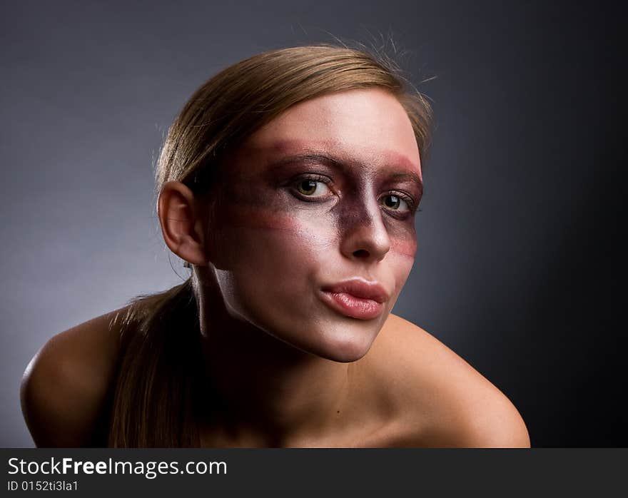 Studio portrait of a young blond woman with aggressive make-up