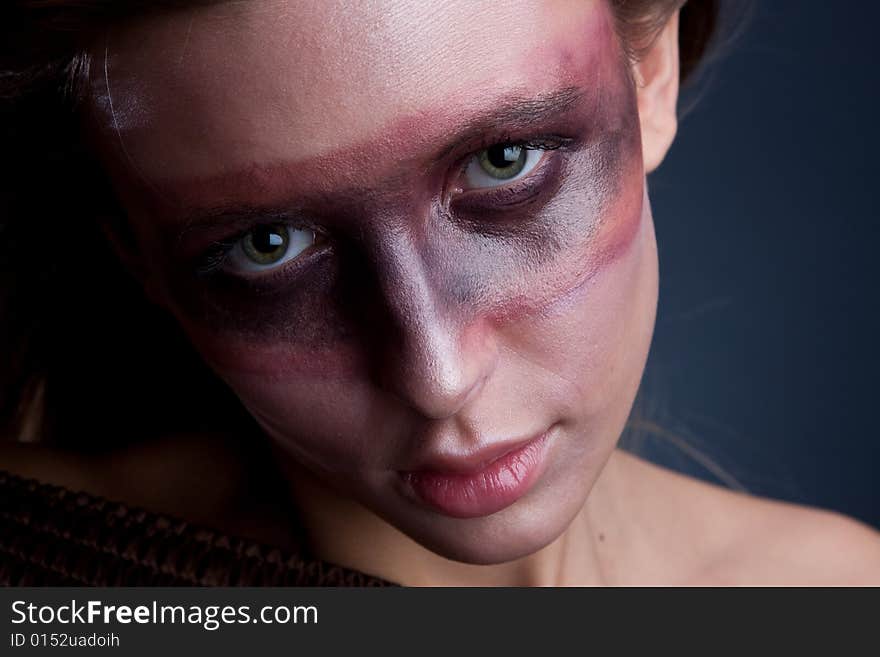 Studio portrait of a young blond woman with aggressive make-up