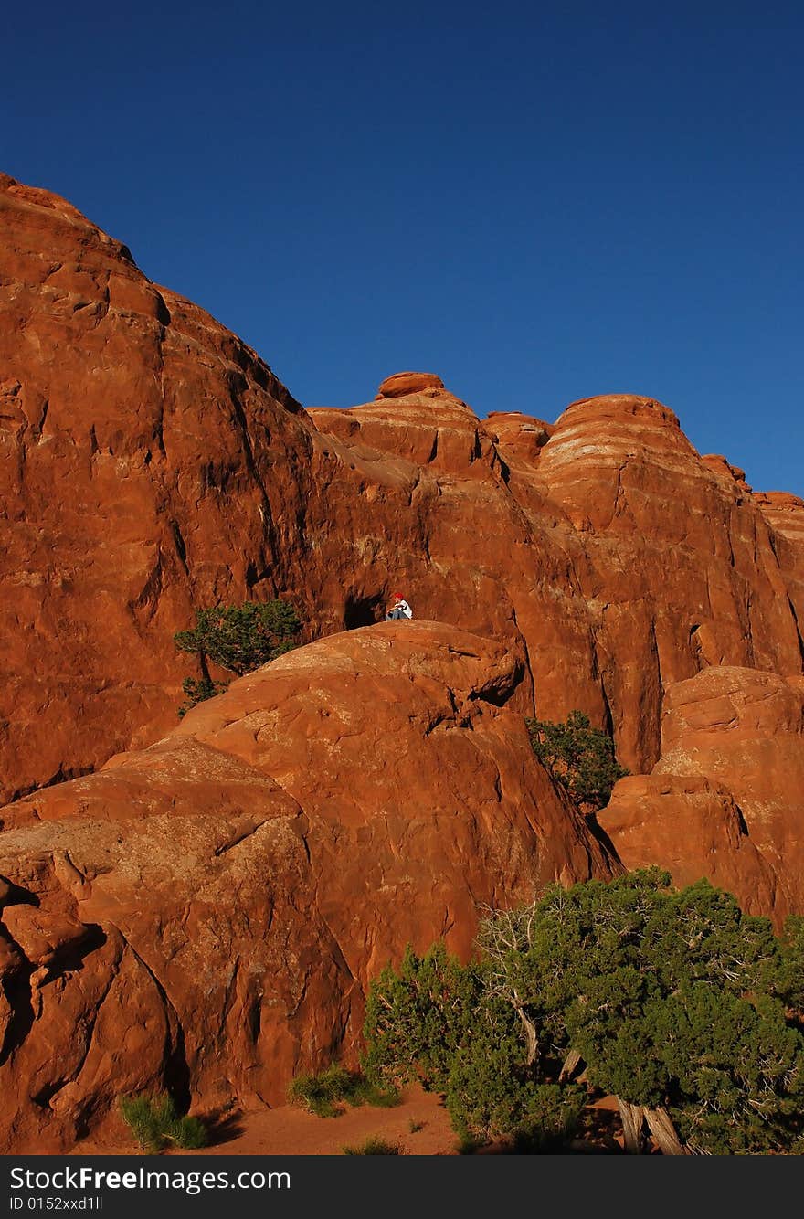 Boy sitting atop one of the great red rocks of Moab, Utah. Boy sitting atop one of the great red rocks of Moab, Utah