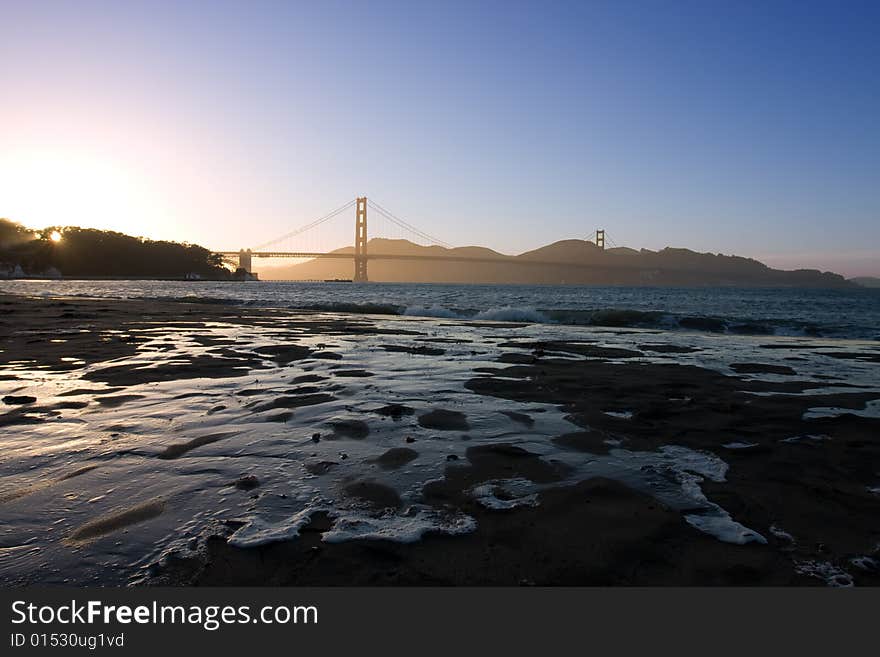 Golden Gate at the dusk with water on sand