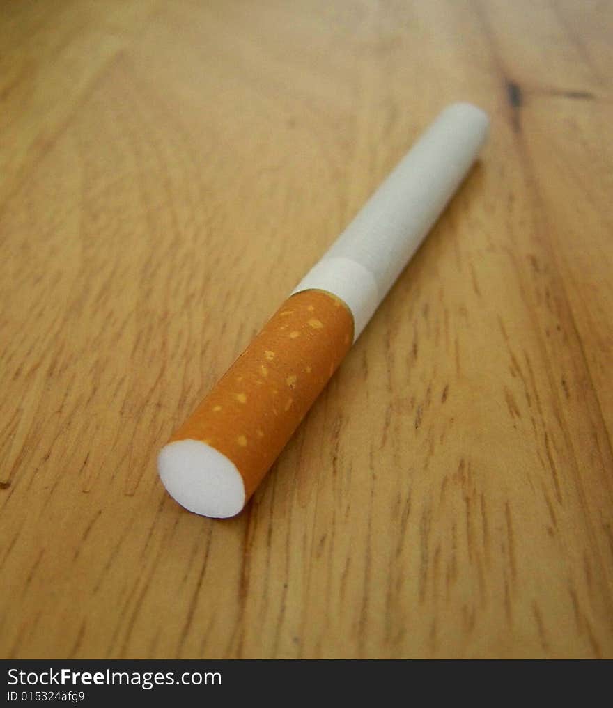 A cigarette on a table, close up. A cigarette on a table, close up