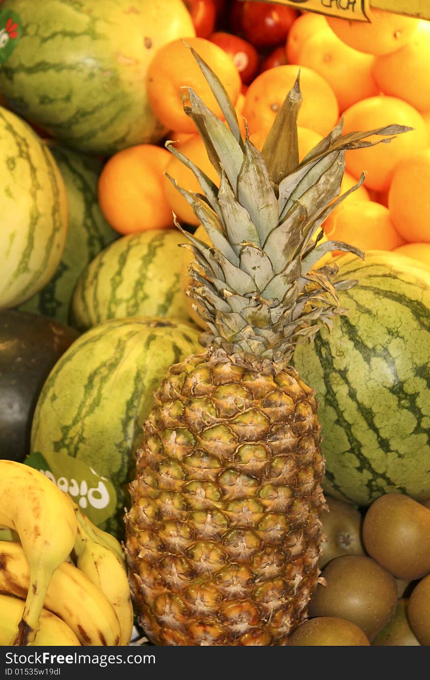 Pineapple, melon, kiwi, banana and orange on a fruit stall awaiting sale. Pineapple, melon, kiwi, banana and orange on a fruit stall awaiting sale